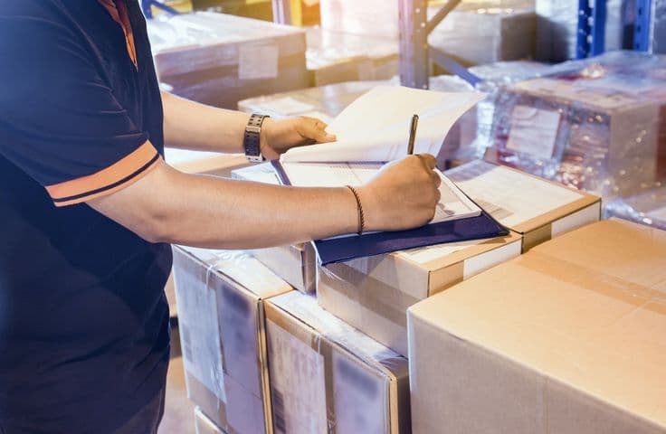 Persona revisando documentos sobre cajas de archivo