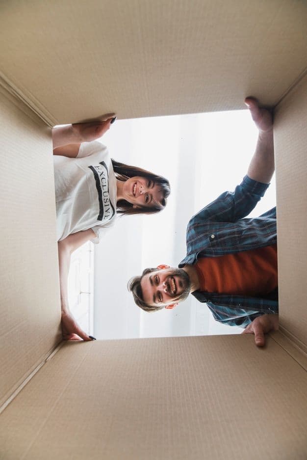 Pareja mirando dentro de una caja de mudanza